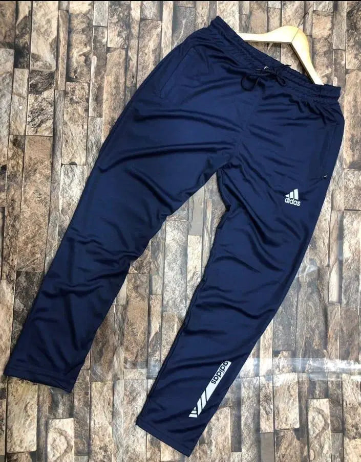 Navy blue Adidas pants on a wooden floor